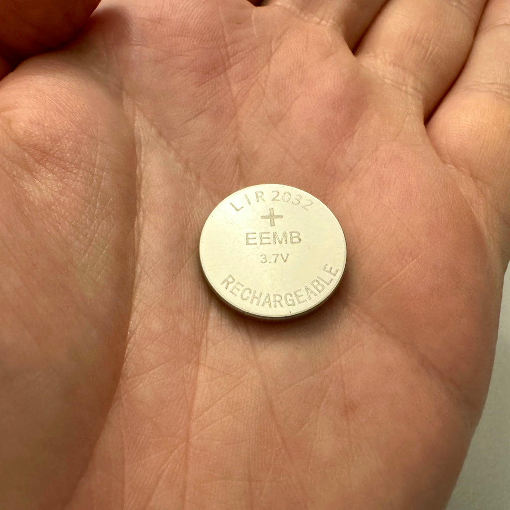 LIR2032 rechargeable coin cell battery held in palm of hand for size comparison, same size as CR2032