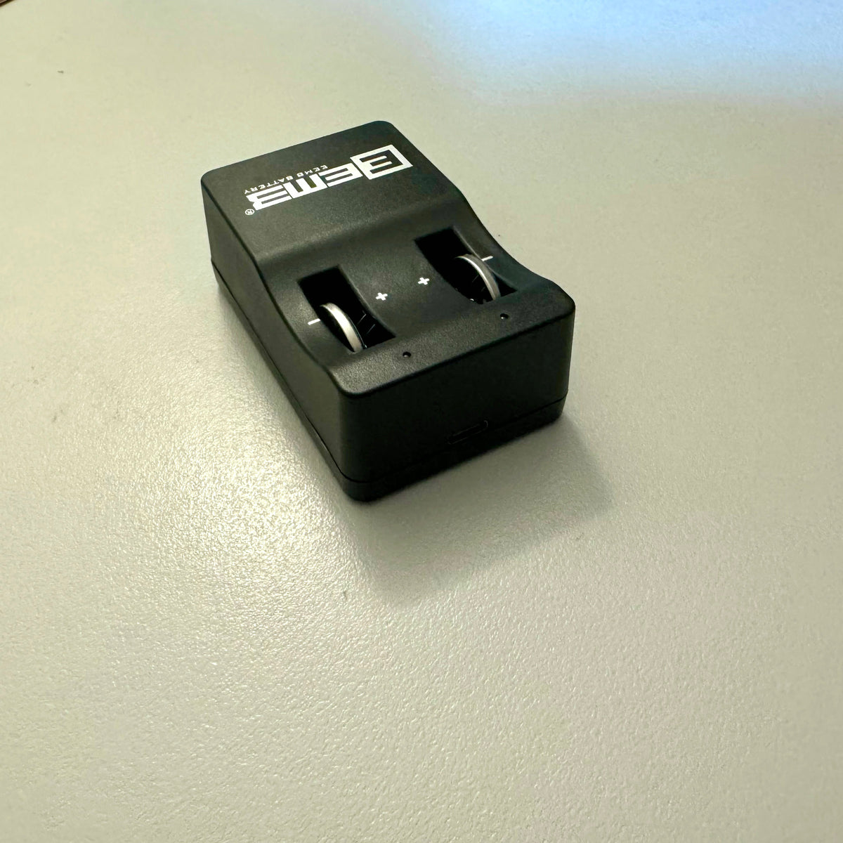 LIR2032 coin cell battery charger showing dual charging slots with polarity markings