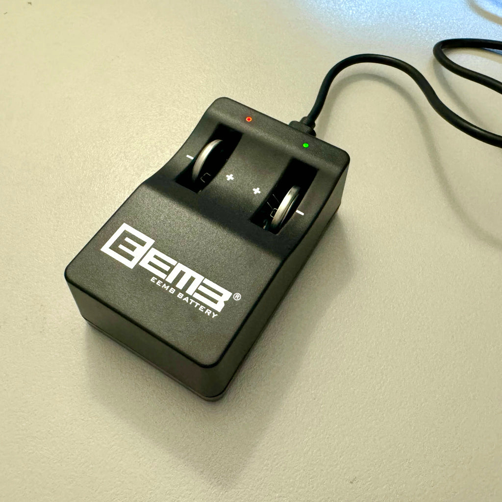 TagCharge USB LIR2032 coin cell battery charger plugged in and charging, red and green indicator lights visible